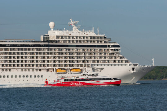 Southampton, England,UK. 2022.  Cruise liner the Seven Seas Splendor a luxury liner makes her way on Southampton Water passing by is a passenger ferry bound for the Isle of Wight.