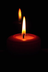 Photo of large burning candles standing on a chest of drawers. Romantic evening for two. Home decor. Comfort and warmth.