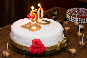 Festive cake with lit golden candles - number 50