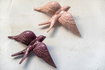 Porcelain pink swallows hanging on a wall
