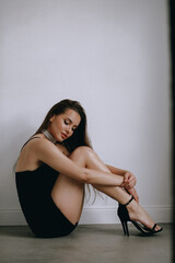 Naklejka premium sexy portrait of brunette in black dress.beauty woman posing in studio