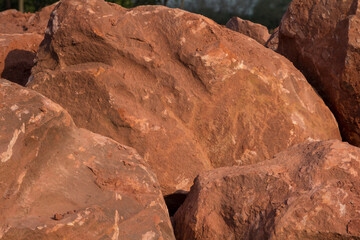 Brown mountain sandstone with large chunks of patterns, designed to be like nature by heavy machinery, beautifully crafted in a vast lakeside garden, perfect for relaxing and watching nature in summer