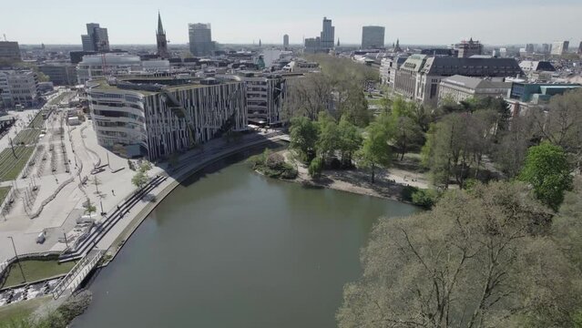 Beautiful view of Dusseldorf cityscape. Public park, shopping mall and tall office building on background - aerial drone