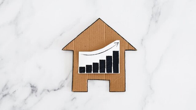 mortgages rentals and property prices increasing, house icon made of cardboard with graph showing stats going up