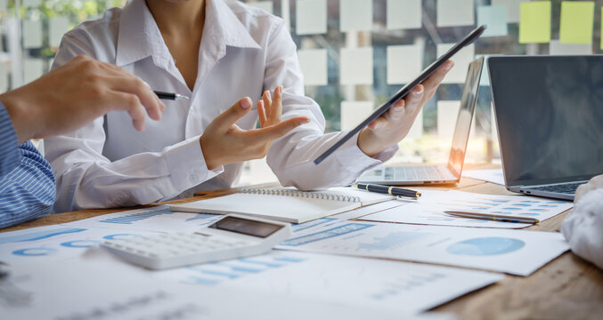 Cropped shot of diverse coworkers working together in a boardroom, working by digital tablet management big data analyze business discussing brainstorming analyzing strategy financial document - Powered by Adobe