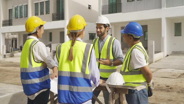 A group of workers, a designer team talk, communicate, discuss, and working on industrial construction site at home architecture building project. People lifestyle.