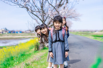 登下校中に通学路で遊ぶ小学生の女の子たち