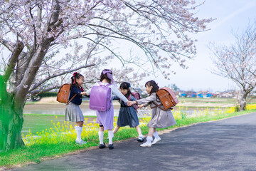 登下校中に通学路で遊ぶ小学生の女の子たち
