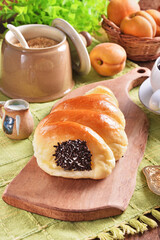 Cream cornet roll bread with raw chocolate on wooden tray