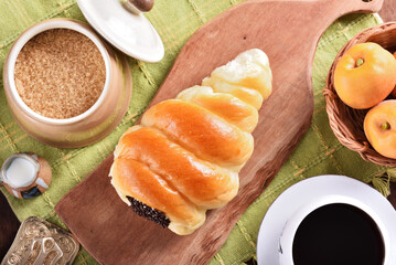 Cream cornet roll bread with raw chocolate on wooden tray