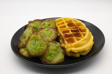 Snacks, waffles and lotus leaf desserts in a black plate,Include Clipping Path.
