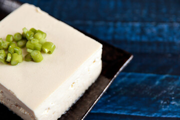 Tofu sprinkled with small green on the table
