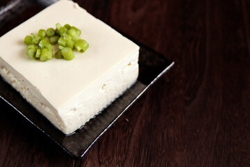 Tofu sprinkled with small green on the table