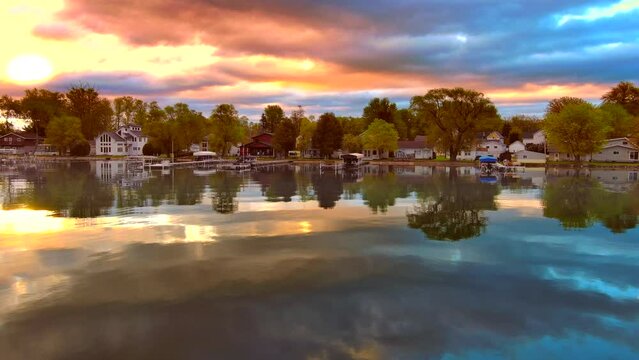 Amazing colorful clouds and sky reflected in tranquil lake at daybreak.