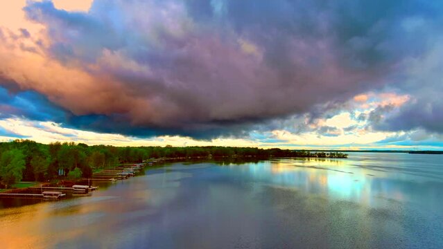 Amazing colorful clouds and sky reflected in tranquil lake at daybreak.