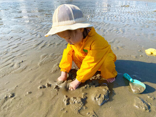 little child playing on the mudflat