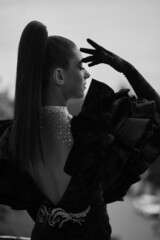 a young girl in an evening dress at the window leaned on the door