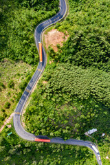 Transporting wind turbine propeller through curvy jungle road. Clean alternative energy to reduce global warming and climate change for sustainable growth.