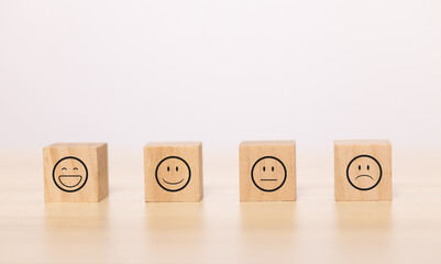 wooden blocks with smiley face graphic. Concept for rating and customer satisfaction.