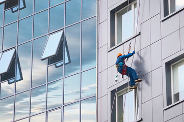 A window cleaner works on the facade of a high-rise office building. © Алексей Игнатов