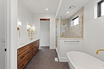 white bathroom with hardwood flooring, white soaker tub and dual sinks