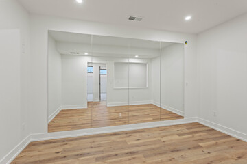 Workout room with mirrors and hardwood flooring