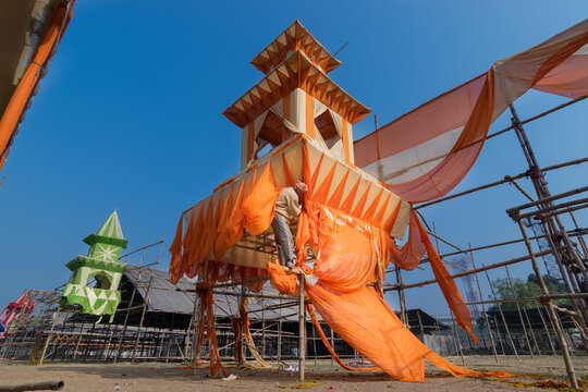 KOLKATA, WEST BENGAL, INDIA - JANUARY 18TH 2015 : Unknown labour dismantling a pandal (a temporary structure made of bamboo and safron clothes), at the end of Gangasagar Mela, Kolkata.