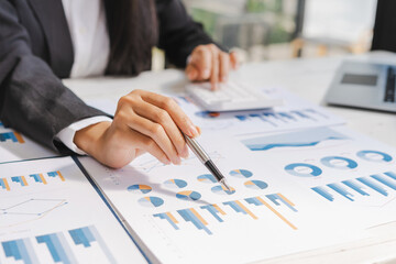Business woman hand pointing business document and analysis data the charts and graphs at desk.
