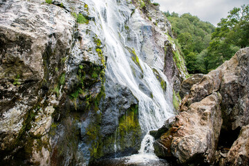 Fototapeta na wymiar Beautiful water cascade of Powerscourt Waterfall, the highest waterfall in Ireland. Famous tourist atractions in co. Wicklow, Ireland. Near Powerscourt Manor House