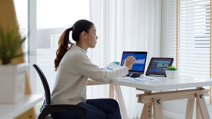 Back rear view of young asian woman, freelance data scientist work remotely at home coding...