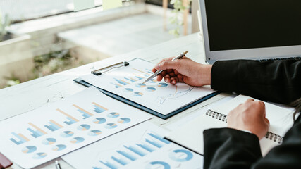 Business analyst working - hand with pen at desk.