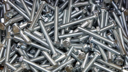 A many new grey large bolts. Galvanized construction fasteners. Technical texture for the background.