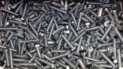 A lot of new gray bolts. Galvanized construction fasteners. Technical texture for background.