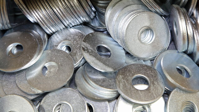 A lot of new gray washers. Galvanized construction fasteners. Technical texture for the background.
