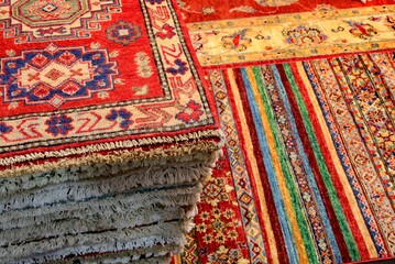 pile of wollen Persian rugs for sale in the shop specializing in home furnishings