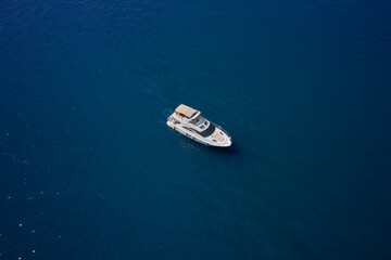 Yacht on blue water. Aerial view luxury motor boat. Top view of the boat.