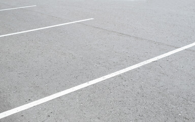 Fototapeta premium White marking lines on asphalt in an empty parking lot, outdoors