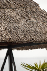 Fototapeta na wymiar An old thatched roof on an umbrella by the sea.
