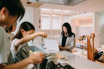 Fototapeta premium 仕事をする母と食事の準備をする父と娘