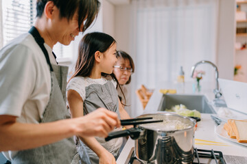 Fototapeta premium 自宅で食事の準備をしている父親と娘