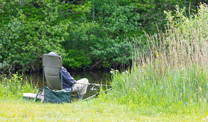 Old man fishing, sitting in a chair