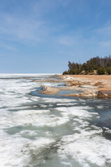 The coast of Lake Baikal covered with the remains of ice and snow on a sunny May day
