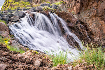 Summer polar landscape with waterfall in Teriberka. Kola Peninsula of the Barents Sea. The nature of the north of Russia