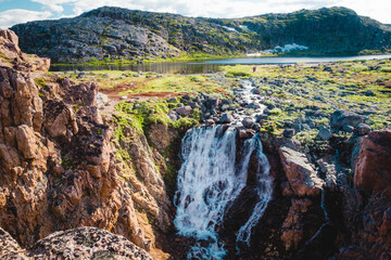 Summer polar landscape with waterfall in Teriberka. Kola Peninsula of the Barents Sea. The nature...