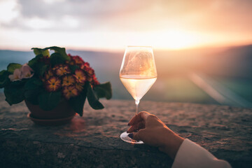 Close up of woman hand holding glass of white wine