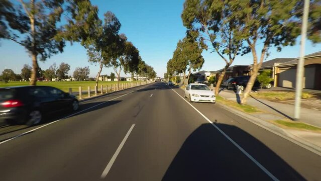 Backview from a car riding an urban road and then turning around. Daylight. Time lapse