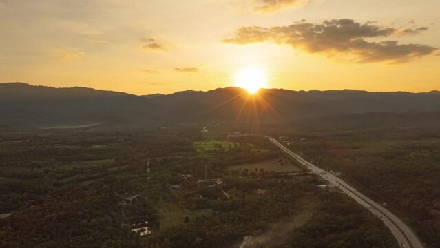 Hyper lapse video 4k motion Aerial view. The train runs on tracks amid a beautiful green forest at sunset.