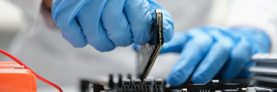 A man in production inserts a microcircuit into a device