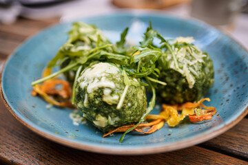 Fototapeta premium Close up of spinach dumplings with melted butter topped with mountain cheese and vegetables. 