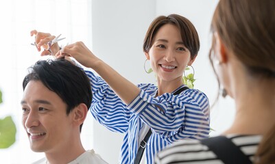 アシスタントにヘアカットを教える女性美容師
